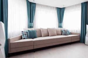 modern couch with pillows matching turquoise draperies