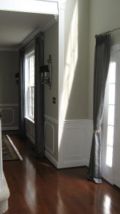 Silk pinch pleated drapes mounted on decorative curtain rods.