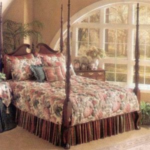 Custom split corner, quilted bed spread with split corners for poster bed. Contrasting pillow shams and throw pillows. Gathered dust ruffle underneath. Custom contrasting table covers on bed side table.