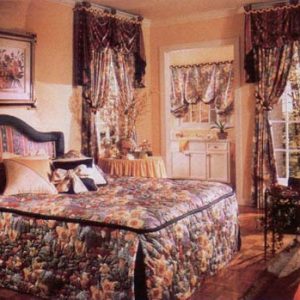 Inverted pleat, quilted pillow wrap bedspread with contrast outline welting around the top. Accent throw pillows and custom headboard. Coordinating balloon shade in bathroom. Swag and Jabot valances with center pelmet over top of Tied Back Pinch Pleated Draperies all done in contrasting fabrics.