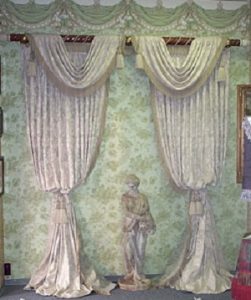 Pinch pleated draperies with bullion fringe and double tassel tie backs.