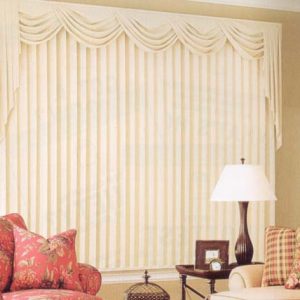 Beautiful wide window dressed with pinch pleated drapery with a swag and jabot valance above.