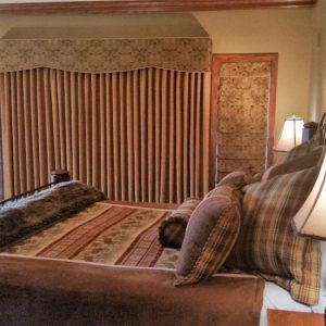 Draperies and cornice covers roman shades over  bedroom window in Chester Springs, PA home. 