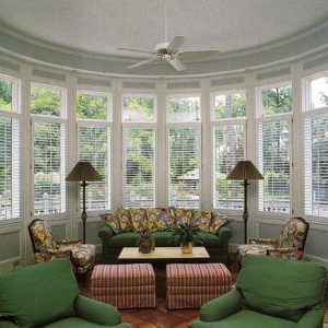 Multiple Single plantation shutter panels with visible tilt bars on each window in this garden room.