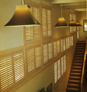 Multi-level wall of stained wooden plantation shutters.