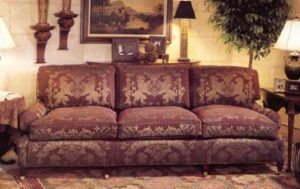 Three seat sofa showcasing large lion crest print centered on each back cushion.
