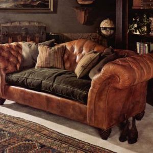 Tufted leather sofa with single velvet covered down seat cushion and accent pillows.