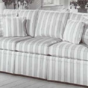 Large skirted sofa in stripe fabric with coordinating block check pillows.