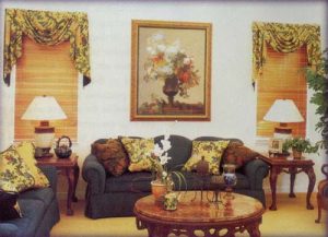 Single swag and jabot valance over wooden blinds coordinating with reupholstered sofa and love seat.