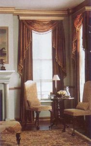 Crown royal wooden molded cornice and multi-fold swag valance and jabots over pinch pleated draperies.