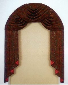 Arched swag and jabot window treatment over Moiré flat roman shade.