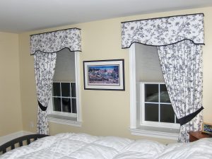 toild fabric shaped cornice over drapery tied back on one side