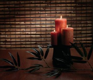 Natural woven wood shade covering window behind decorative candles.